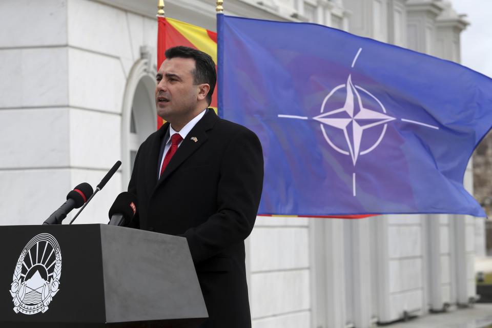 Macedonian Prime Minister Zoran Zaev delivers a speech in front of the NATO flag during a ceremony at the government building in Skopje, Tuesday, Feb. 12, 2019. Macedonian authorities began removing official signs from government buildings to prepare for the country's new name: North Macedonia. (AP Photo/Dragan Perkovksi)