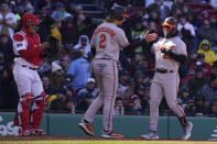 Baltimore Orioles' Ramon Urias, right, is congratulated by Gunnar Henderson (2) after his two-run home run off Boston Red Sox starting pitcher Corey Kluber, Thursday, March 30, 2023, in Boston. At left is Boston Red Sox catcher Reese McGuire. (AP Photo/Charles Krupa)