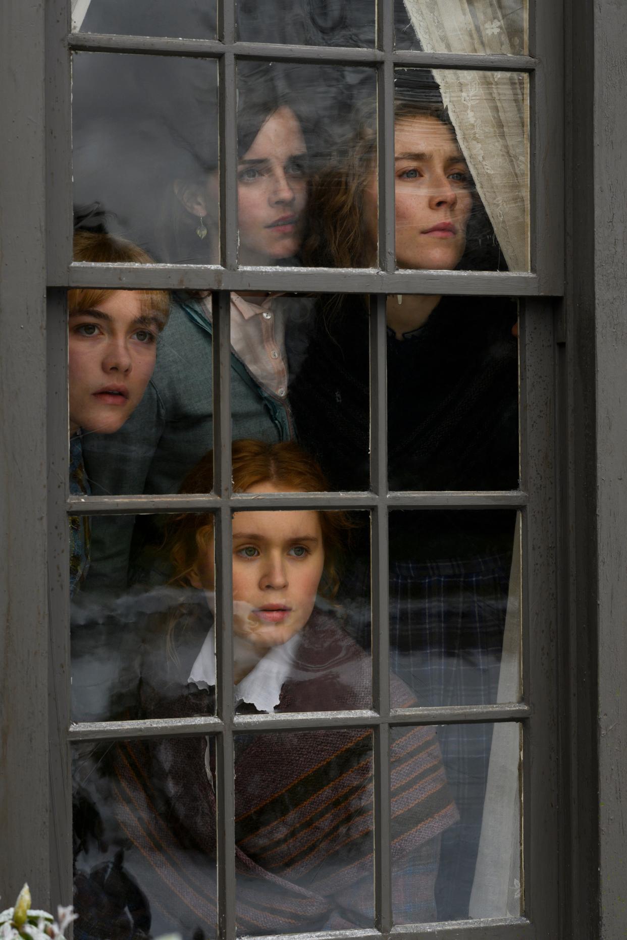 The March sisters - Amy (Florence Pugh, from left), Meg (Emma Watson), Beth (Eliza Scanlen) and Jo (Saoirse Ronan) - look into the future in Greta Gerwig's new version of "Little Women."