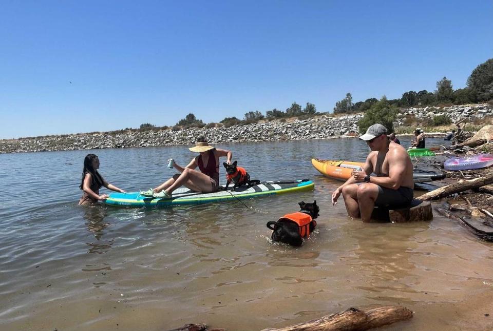 Zach Christensen, accompanied by his wife, Olivia, and colleague Rachel Conshue (left), enjoy the cool waters of Folsom Lake on Saturday afternoon during the hottest day of the year in celebration of Independence Day.