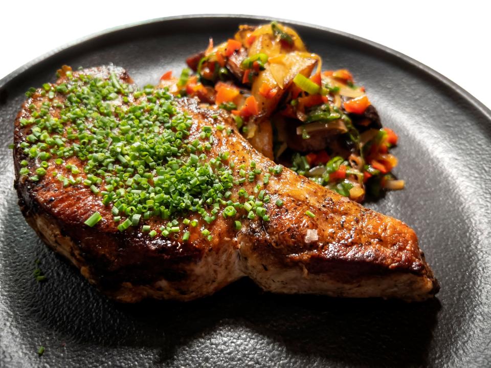 A Niman Ranch Iberian Duroc Pork chop is served with sweet pepper chutney and fingerling potato at Stage Kitchen and Bar in Palm Beach Gardens.