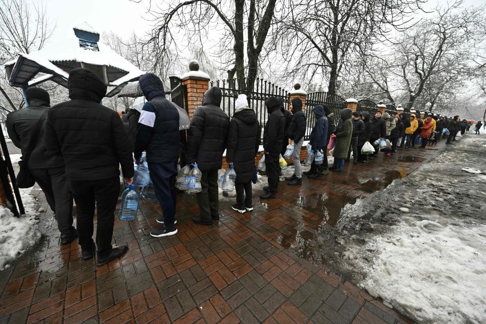 Local residents queue for access to a water pump in a park to fill plastic bottles in Kyiv (AFP via Getty Images)