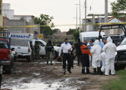 Forensic service personnel prepare to enter an unregistered drug rehabilitation center in Irapuato, Mexico, Wednesday, July 1, 2020. Gunmen burst into the rehab center and opened fire, killing more than 20 and wounding several more. (AP Photo/Mario Armas)