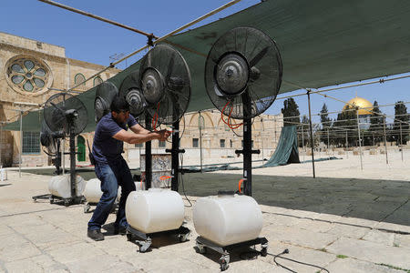 An employee of the Jordanian Waqf, or Islamic trust, that oversees the area, fixes mist cooler fans during preparations for the Muslim holy month of Ramadan on the compound known to Muslims as al-Haram al-Sharif and to Jews as Temple Mount, in Jerusalem's Old City May, 10, 2017. REUTERS/Ammar Awad