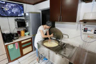 Natalia Kurochkina works on the process of making cheese at her family dairy and cheese farm in the Siberian village of Sizaya, south of Krasnoyarsk, Russia August 8, 2018. REUTERS/Ilya Naymushin