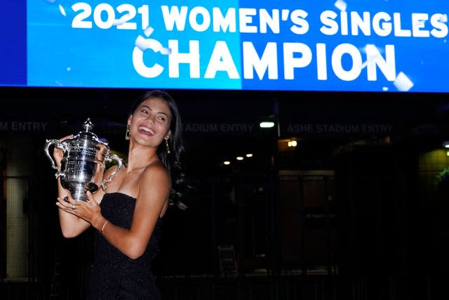 Emma Raducanu poses outside Arthur Ashe Stadium with the US Open trophy