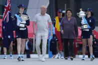 Former Grand Slam champions Andre Agassi and Evonne Goolagong Cawley walk with ball kids carrying the women’s, Daphne Akhurst Memorial Cup and the men’s Norman Brookes Challenge Cup trophies ahead of the start of Australian Open tennis championships at Melbourne Park, Melbourne, Australia, Sunday, Jan. 14, 2024. (AP Photo/Andy Wong)
