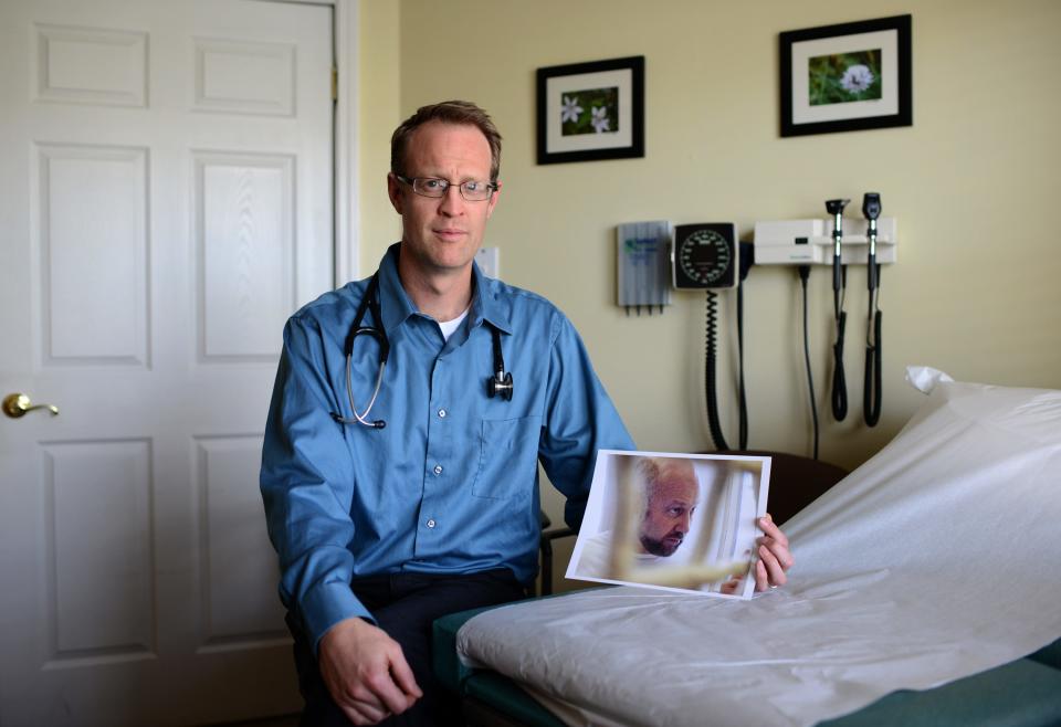 Dr. Benjamin Gilmer holds a photograph of Vince Gilmer in April 2013.