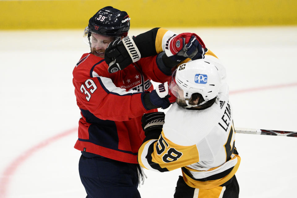 Washington Capitals right wing Anthony Mantha (39) and Pittsburgh Penguins defenseman Kris Letang (58) scuffle during the third period of an NHL hockey game, Thursday, Jan. 26, 2023, in Washington. (AP Photo/Nick Wass)