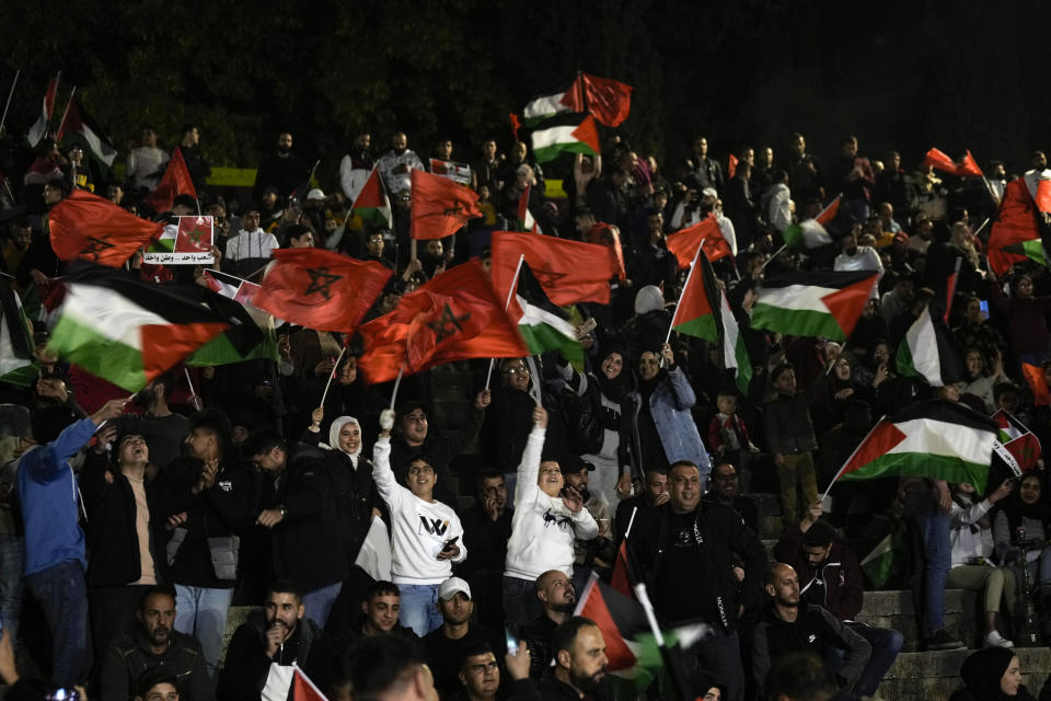 FILE - Palestinians wave Moroccan and Palestinian flags as they watch a live broadcast of the World Cup quarterfinal soccer match between Morocco and Portugal played in Qatar, in the West Bank town of Nablus, Saturday, Dec. 10, 2022. (AP Photo/Majdi Mohammed, File)