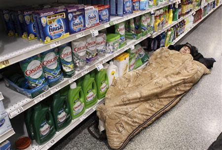 Kienan Dietrich sleeps at the aisle of a Publix grocery store after being stranded due to a snow storm in Atlanta, Georgia, January 29, 2014. REUTERS/Tami Chappell