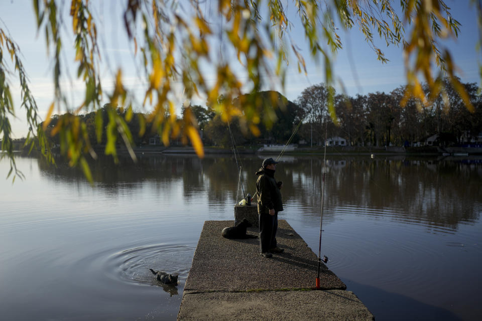 Alejandro Ramos fishes in the Rio Gualeguaychu river in the Entre Rios province of Argentina, a few kilometers from the Uruguayan border, Saturday, July 1, 2023. Ramos, a 49-year-old Argentine teacher who lives in Gualeguaychú, thinks the problem of Uruguayans taking advantage of Argentina's exchange rate for bargain shopping is not the Uruguayans because “they come and buy legally.” The problem “is us; we first have to realize that we are an economic disaster in this country.” (AP Photo/Natacha Pisarenko)