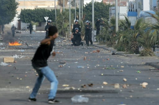 A member of the Tunisian security forces takes aim towards a demonstrator who prepares to throw a rock towards them during clashes in January 2011 near Sidi Bouzid