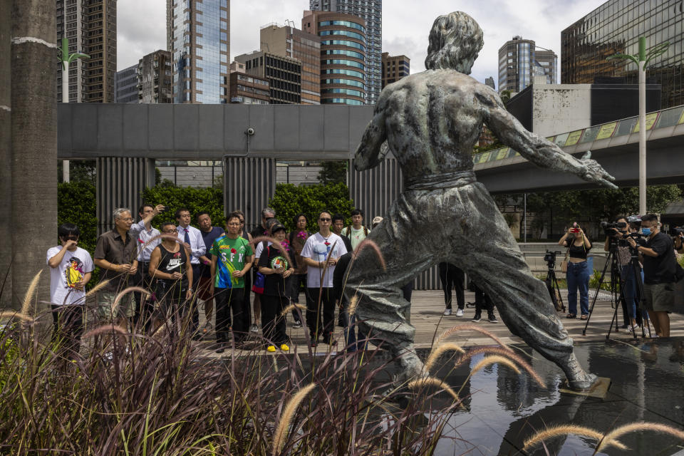 Fans gather in front of the statue of martial artist Bruce Lee to commemorate the 50th anniversary of his death in Hong Kong, Thursday, July 20, 2023. (AP Photo/Louise Delmotte)