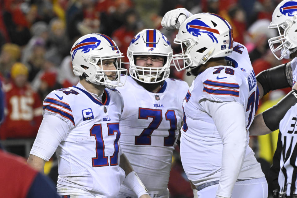 Buffalo Bills quarterback Josh Allen (17) is congratulated by offensive tackle Daryl Williams (75) and guard Ryan Bates (71) after throwing a touchdown against the Kansas City Chiefs during the second half of an NFL divisional playoff football game, Sunday, Jan. 23, 2022 in Kansas City, Mo. (AP Photo/Reed Hoffmann)