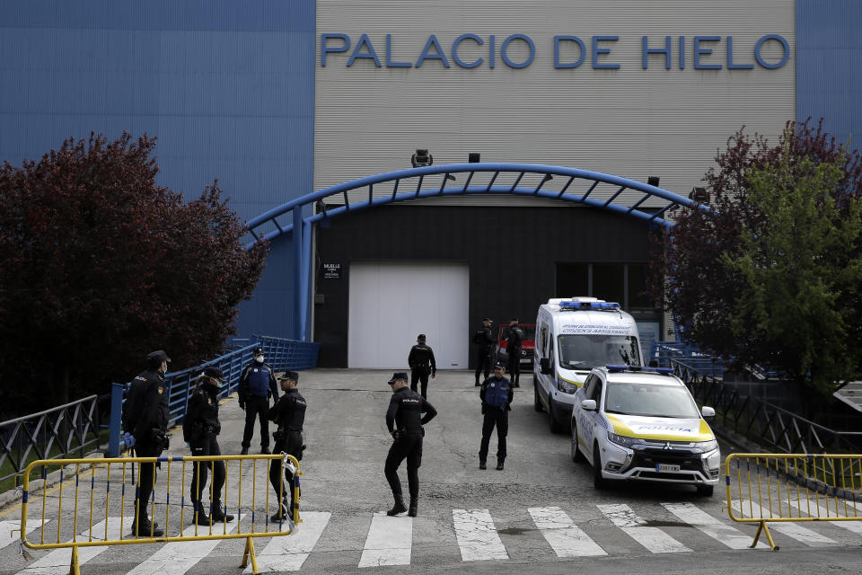 Police officers stand in front of Madrid's ice rink turned into a temporary morgue due the COVID-19 crisis in Madrid, Spain, Tuesday, March 24, 2020. Madrid's ice-skating rink is now being used as a makeshift morgue given the rapid increase in deaths in the Spanish capital. For some people the COVID-19 coronavirus causes mild or moderate symptoms, but for some, it can cause severe illness, especially in older adults and people with existing health problems. (AP Photo/Manu Fernandez)