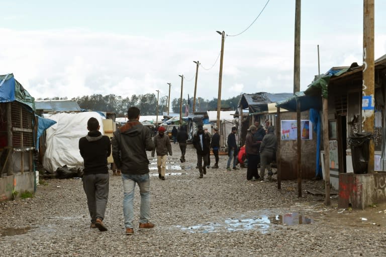 Migrants walks through the "Jungle" migrant camp in Calais, northern France, on October 22, 2016