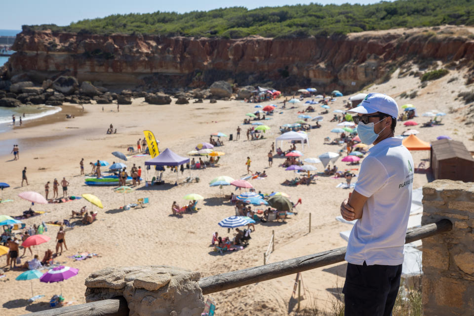 CONIL DE LA FRONTERA, SPAIN - JUNE 28: An assistant observes the beach of Cala del Aceite to control overcrowding on June 28, 2020 in Conil de la frontera, Spain.On June 21 the Government announced the end of the alarm state relating to Covid-19. (Photo by Juan Carlos Toro/Getty Images)