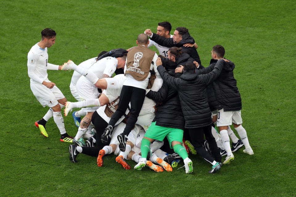 <p>Over the moon: Uruguay players and subs celebrate their late winner. (EFE/EPA/MAHMOUD KHALED) </p>