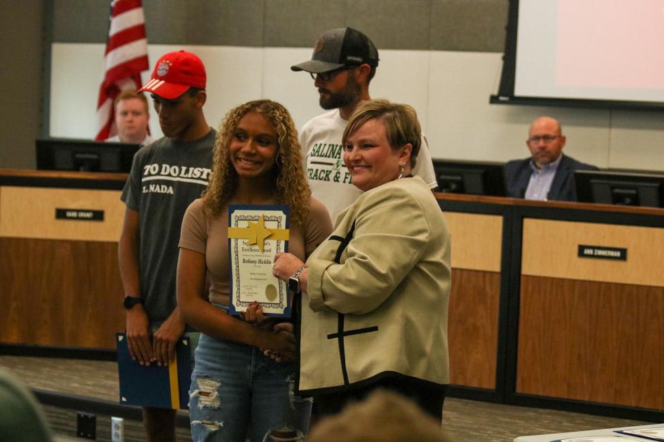 Salina South sophomore Bethany Hicklen (left) is recognized Tuesday by Superintendent Linn Exline. Hicklen placed 5th in Pole Vault in state competition last spring.