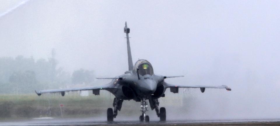 FILE- In this Thursday, Sept. 10, 2020, file photo, water is sprayed on a French-made Rafale fighter jet during its induction ceremony at the Indian Air Force Station in Ambala, India. Greece's government says on Thursday, Dec. 17, 2020, it will pay 2.32 billion euros ($2.8 billion) for the purchase of French-made Rafale fighter jets and an upgrade of compatible air-to-air missile systems and part of a major military overhaul. (AP Photo/Manish Swarup, File)