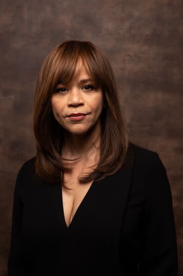 Woman, Rosie Perez, posing in black with slight smile at Sundance Film Festival with long brown hair with bangs