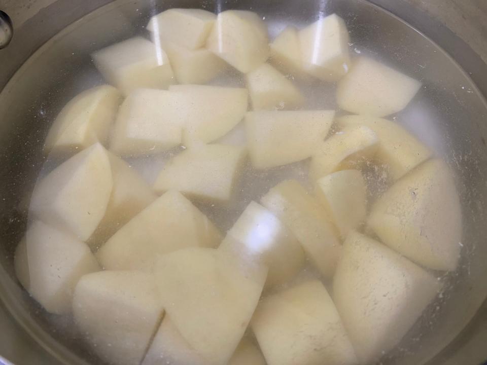 chunks of potato in water in a pot on the stove