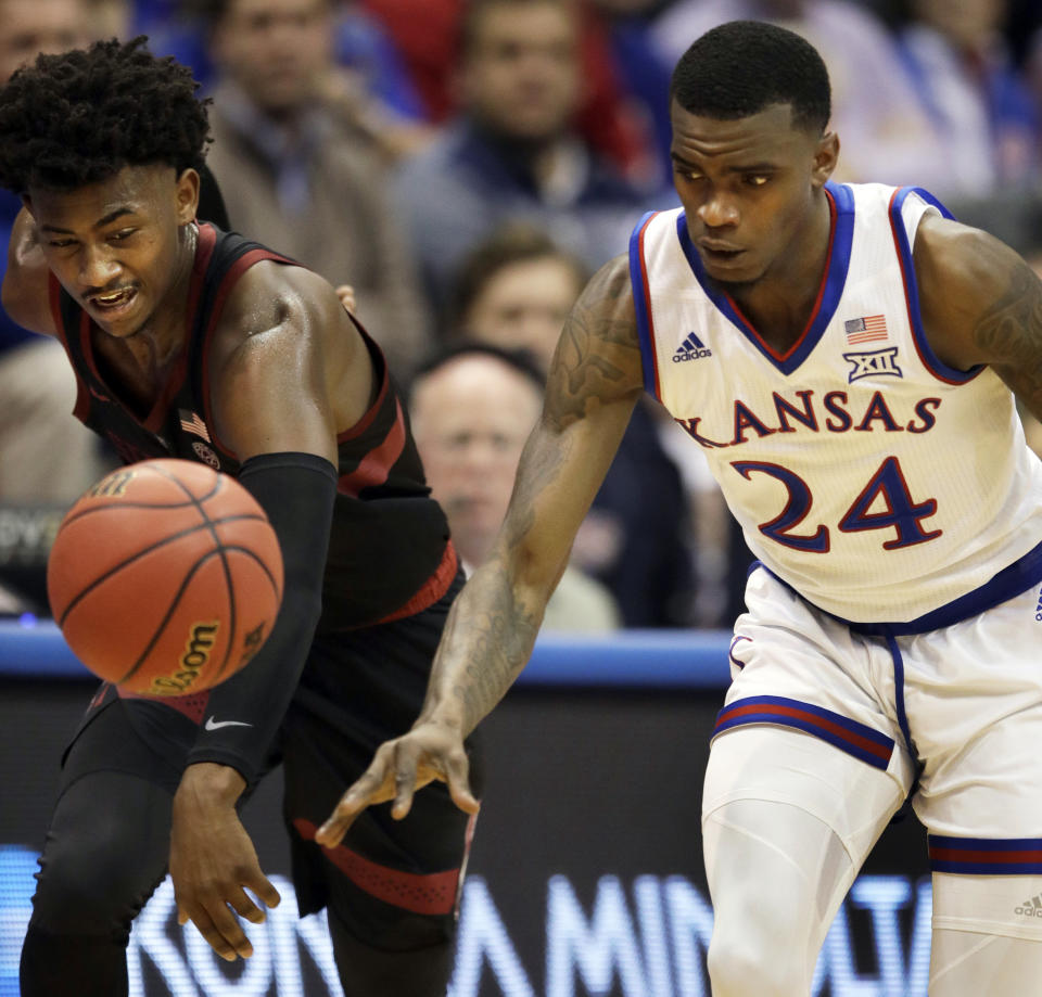 Stanford guard Daejon Davis, left, knocks the ball from Kansas guard Lagerald Vick (24) during the first half of an NCAA college basketball game in Lawrence, Kan., Saturday, Dec. 1, 2018. (AP Photo/Orlin Wagner)