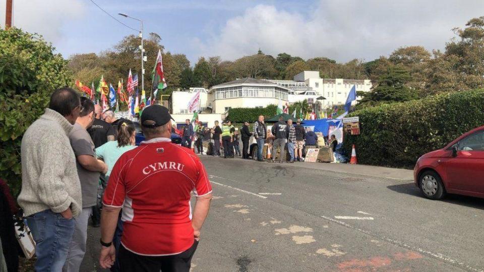 Outside Stradey Park hotel on Tuesday where crowds have gathered, there are also a couple of police officers standing there