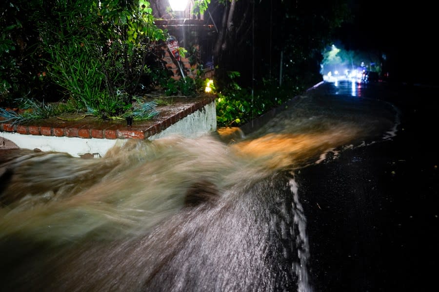 Water pours down Fryman Rd. during a rain storm Monday, Feb. 5, 2024, in Studio City Calif. The second of back-to-back atmospheric rivers took aim at Southern California, unleashing mudslides, flooding roadways and knocking out power as the soggy state braced for another day of heavy rains. (AP Photo/Marcio Jose Sanchez)