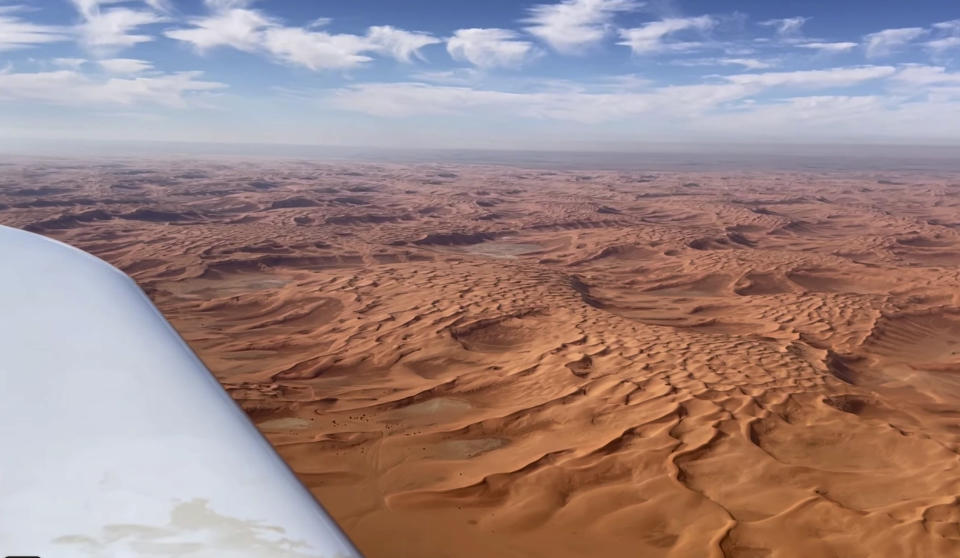 In this undated photo provided by FlyZolo, Zara Rutherford flies over the Saudi Arabian desert in her Shark ultralight plane. Rutherford is set to land in Kortrijk, Belgium on Monday, Jan. 17, 2022, in the hopes of completing her trek around the world as the youngest woman ever, beating the mark of American aviator Shaesta Waiz, who was 30 when she set the previous benchmark. (FlyZolo via AP)