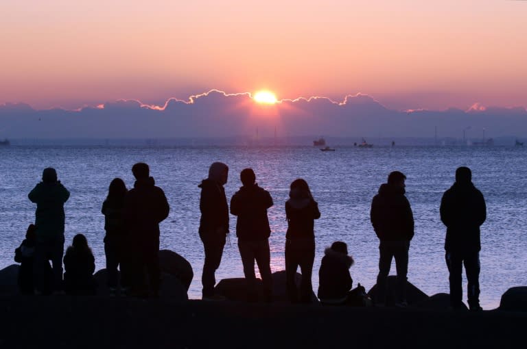 People watch the sun rise on New Year's Day over Tokyo Bay on January 1, 2016