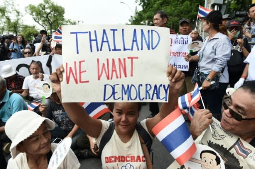 Demonstrators gather near a police barricade outside Thammasat University during a protest to mark the fourth year of junta rule in Bangkok