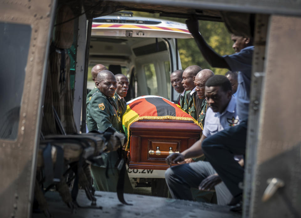 The casket of former president Robert Mugabe is carried by the presidential guard into an air force helicopter for transport to a stadium where it will lie in state, at his official residence in the capital Harare, Zimbabwe Friday, Sept. 13, 2019. The ongoing uncertainty of the burial of Mugabe, who died last week in Singapore at the age of 95, has eclipsed the elaborate plans for Zimbabweans to pay their respects to the former guerrilla leader at several historic sites. (AP Photo/Ben Curtis)