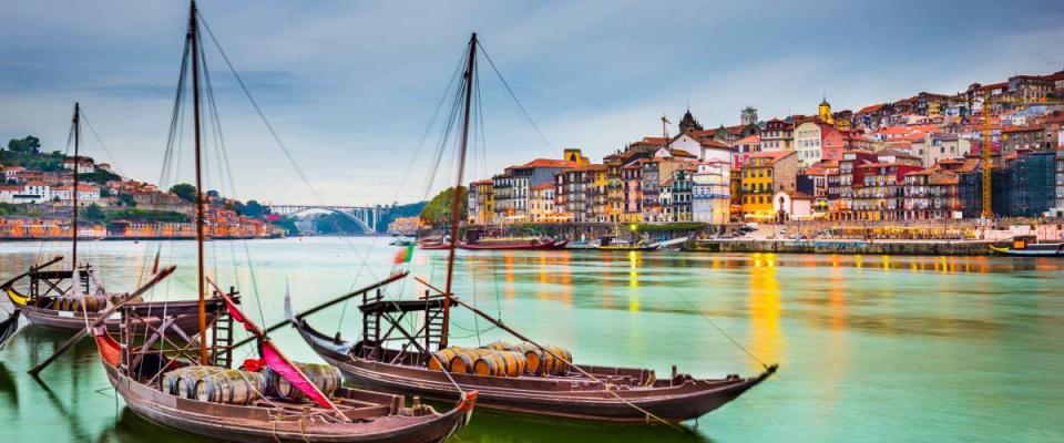 Porto, Portugal old town cityscape on the Douro River with traditional Rabelo boats.