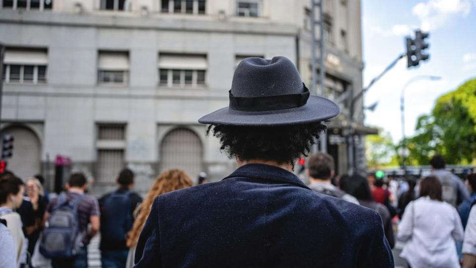 Hombre con sombrero cruza la calle.