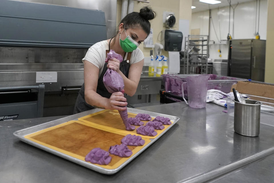 Lauren Scully, a pastry chef at The Lakehouse, a restaurant located in Bellevue, Wash., prepares a tray of Huckleberry Bavarian desserts as she works in the kitchen at Lumen Field, Thursday, Feb. 18, 2021, in Seattle. Scully was one of the chefs taking part in the inaugural night of the "Field To Table" event at stadium, which is home to the Seattle Seahawks NFL football team. The event will feature several weeks of dates that offer four-course meals cooked by local chefs and served at tables socially distanced as a precaution against the COVID-19 pandemic. (AP Photo/Ted S. Warren)