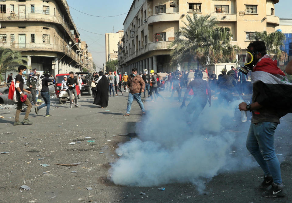 Riot police fire tear gas to disperse anti-government protesters during clashes on Rasheed Street in Baghdad, Iraq, Tuesday, Nov. 26, 2019. (AP Photo/Hadi Mizban)