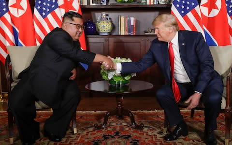 US President Donald Trump shakes hands with North Korea leader Kim Jong Un during their first meetings at the Capella resort on Sentosa Island Tuesday - Credit:  Evan Vucci/AP