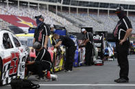 Crew members works on cars along pit road prior to qualifying for a NASCAR Cup Series auto race at Charlotte Motor Speedway Sunday, May 24, 2020, in Concord, N.C. (AP Photo/Gerry Broome)