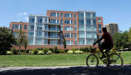 A cyclist makes his way past a building in Alexandria, Virginia, August 9, 2017, that contains a unit listed to Paul Manafort. REUTERS/Kevin Lamarque