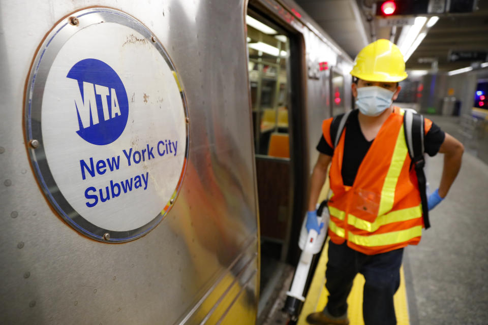 Contractors clean subway cars at the 96th Street station to control the spread of COVID-19, Thursday, July 2, 2020, in New York. Mass transit systems around the world have taken unprecedented — and expensive — steps to curb the spread of the coronavirus, including shutting down New York subways overnight and testing powerful ultraviolet lamps to disinfect seats, poles and floors. (AP Photo/John Minchillo)