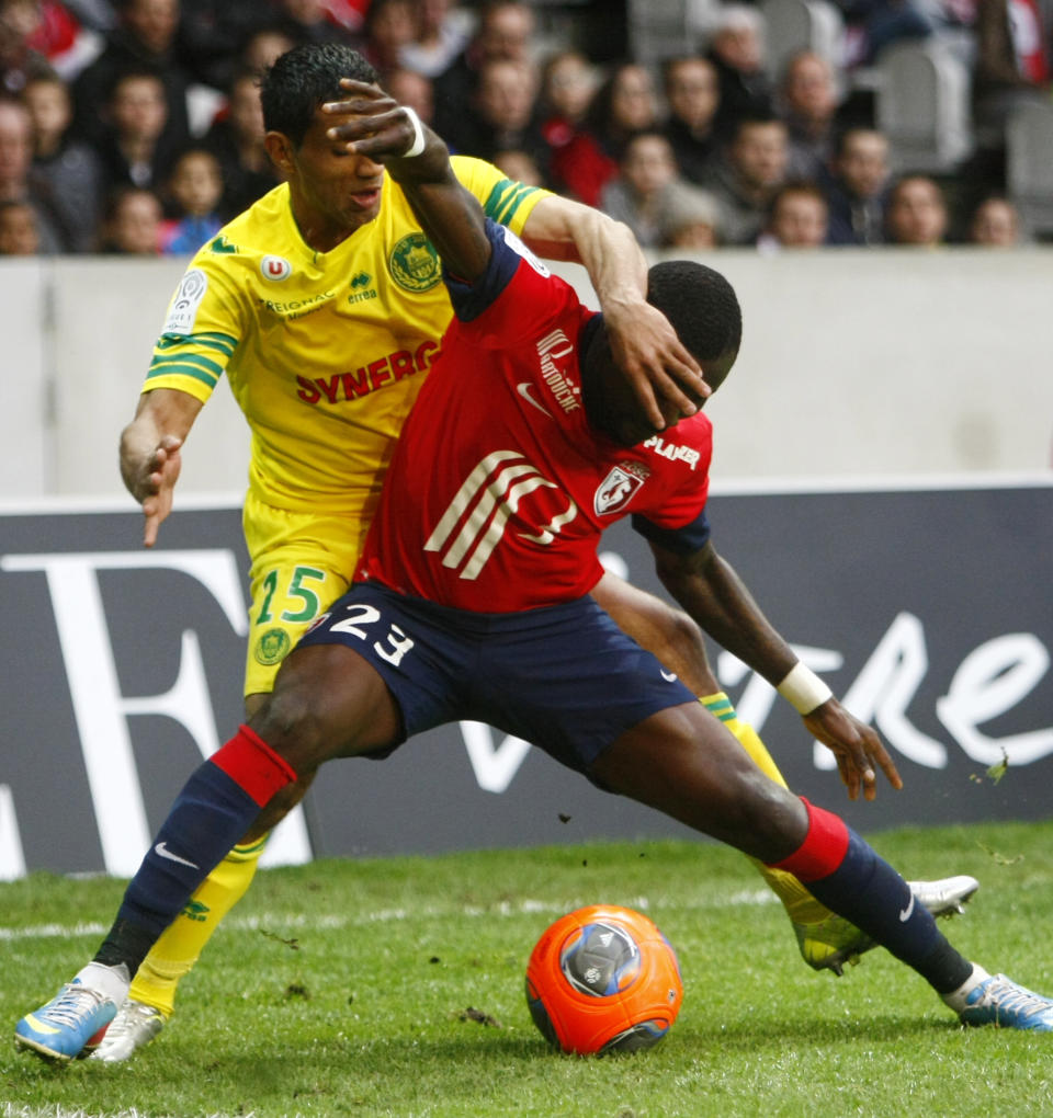 Nantes' Banel Nicolita and Lille's Adama Soumaoro, front, challenge the ball during their French League one soccer match at the Lille Metropole stadium, in Villeneuve d'Ascq, northern France, Saturday, March 15, 2014. (AP Photo/Michel Spingler)