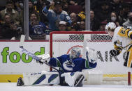 Vancouver Canucks goalie Thatcher Demko makes a save as Pittsburgh Penguins' Brock McGinn watches during the second period of an NHL hockey game Saturday, Dec. 4, 2021, in Vancouver, British Columbia. (Darryl Dyck/The Canadian Press via AP)