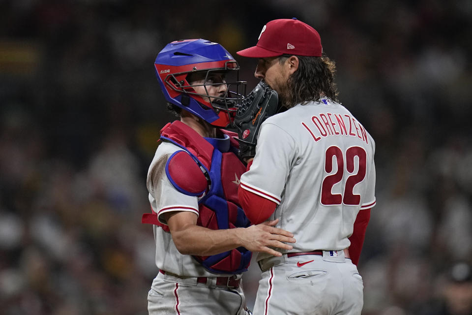 Philadelphia Phillies starting pitcher Michael Lorenzen, right, talks with catcher Garrett Stubbs during a mound visit in the sixth inning of a baseball game against the San Diego Padres, Tuesday, Sept. 5, 2023, in San Diego. (AP Photo/Gregory Bull)