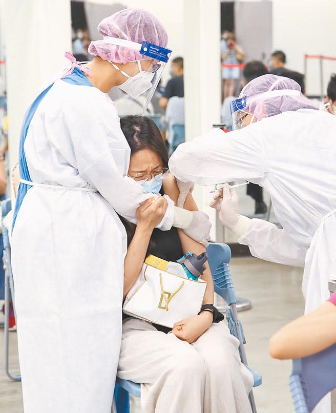 29日台北市長庚注射站，一位打第一劑BNT疫苗的民眾，因害怕打針現場落淚，醫護貼心抱緊安慰，完成接種。（陳俊吉攝）