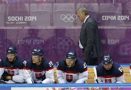 Slovakia's head coach Vladimir Vujtek walks on the bench behind his players during the third period of their men's preliminary round ice hockey game against Slovenia at the 2014 Sochi Winter Olympic Games, February 15, 2014. REUTERS/Grigory Dukor