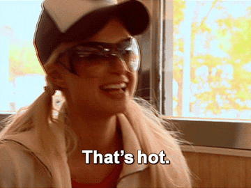 Paris Hilton wearing a cap and sunglasses smiling with the text "That's hot."