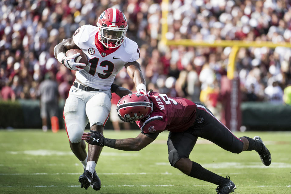 Georgia running back Elijah Holyfield (13) runs with the ball against South Carolina defensive back Keisean Nixon (9) during the first half of an NCAA college football game Saturday, Sept. 8, 2018, in Columbia, S.C. (AP Photo/Sean Rayford)