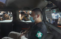 A 23-year-old man, Tong Ying-kit, arrives at a court in a police van in Hong Kong Monday, July 6, 2020. Tong has become the first person in Hong Kong to be charged under the new national security law, for allegedly driving a motorcycle into a group of policemen while bearing a flag with the "Liberate Hong Kong, revolution of our time" slogan. (AP Photo/Vincent Yu)